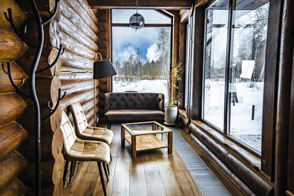 uma sala de estar com um sofá, uma mesa e uma janela em Загородный экопарк и глэмпинг Легенды Леса em Uglich