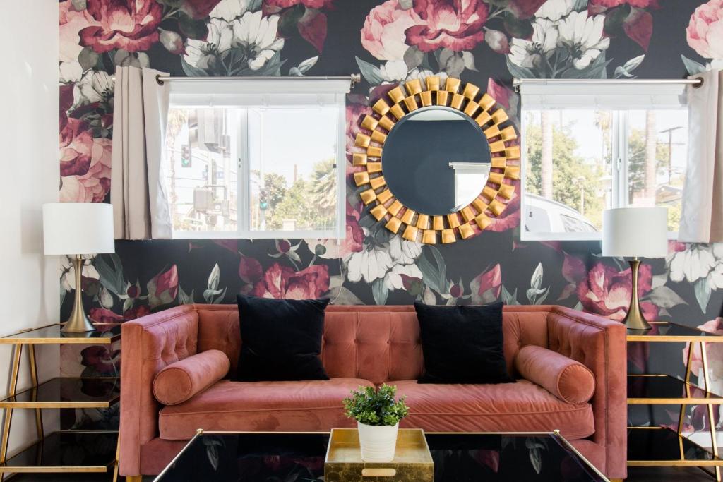 a living room with a brown couch and floral wallpaper at Art Deco Townhouse in the Heart of Hollywood in Los Angeles