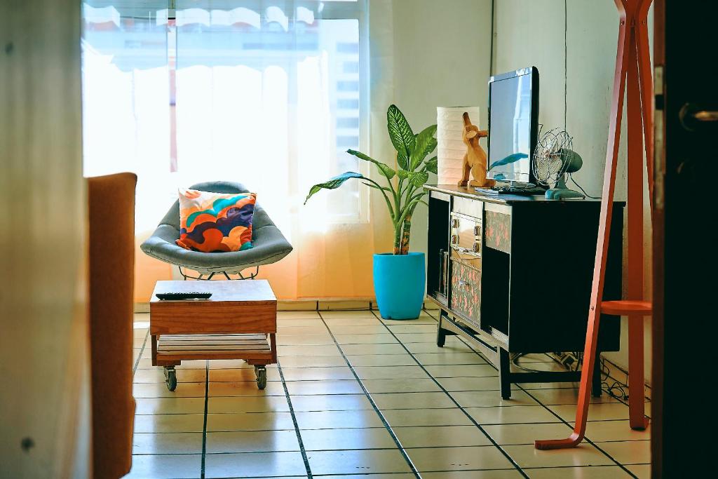 un soggiorno con sedia e TV di Saint Martin Apartments a Guadalajara