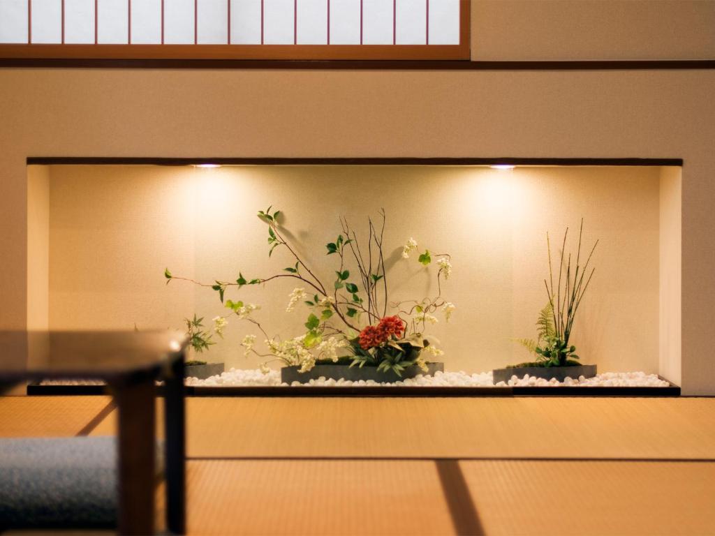 a wall with two potted plants on a shelf at House Hotel Kenrokuzaka in Kanazawa
