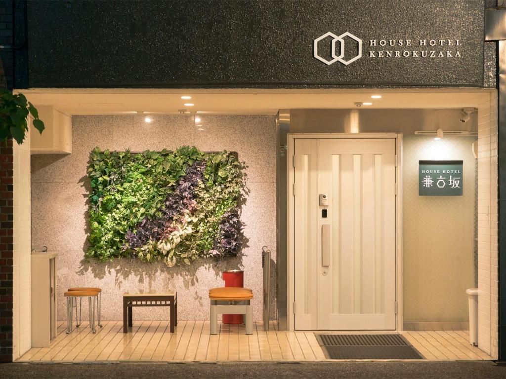 a building with a plant on the wall at House Hotel Kenrokuzaka in Kanazawa