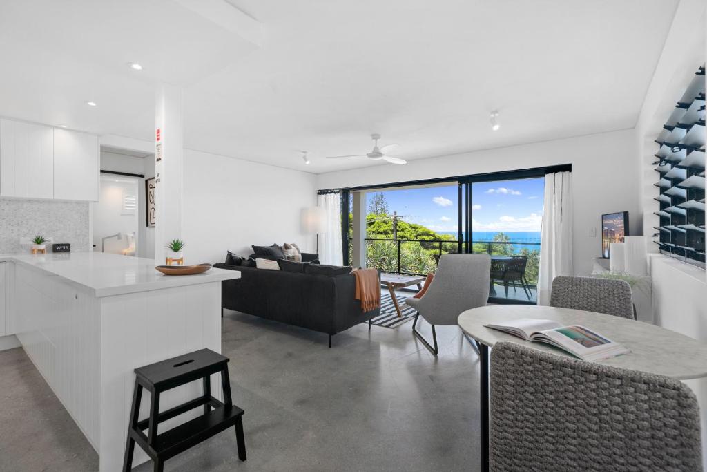 a kitchen and living room with a couch and a table at Oceanbreeze - Sunshine Beach Ocean Views in Sunshine Beach