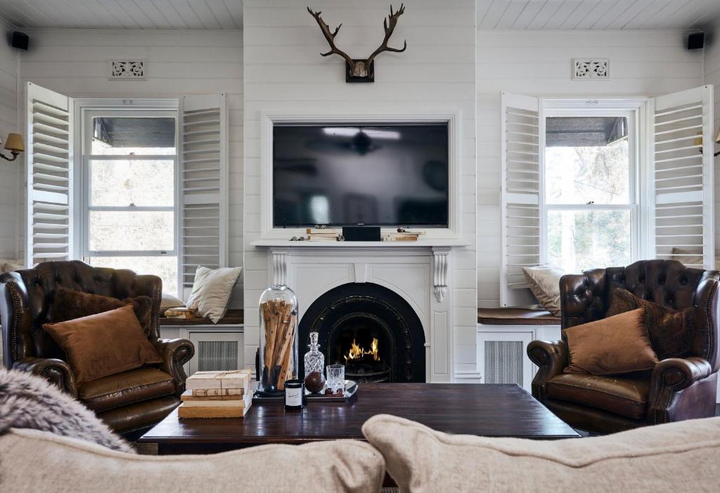 a living room with a fireplace and a tv at The Blackwood Sassafras in Sassafras