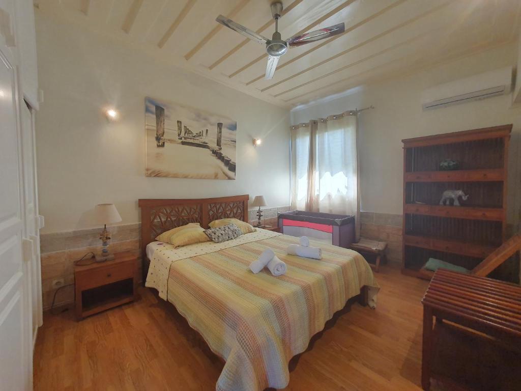 a bedroom with a bed and a ceiling fan at VILLA Tsara in Petite Île