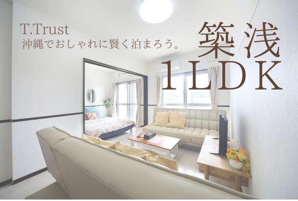 uma sala de estar com um sofá e um espelho em EX Itoman Apartment 502 em Itoman