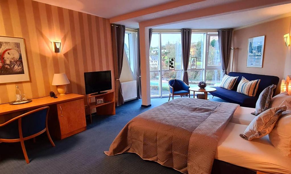 a hotel room with a bed and a television at Saar Galerie in Saarburg