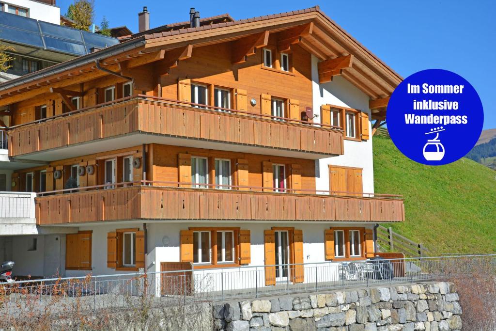 a building with a sign that reads in summer institutewaukeewaukeewyss at Schützenrain 1. Stock in Adelboden