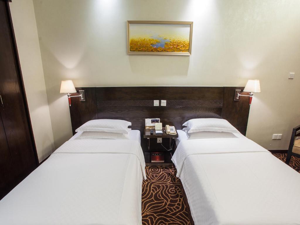 Postel nebo postele na pokoji v ubytování Hua Shi Hotel