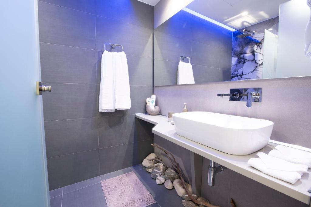łazienka z białą umywalką i lustrem w obiekcie Αqua Dream Beach Apartment w mieście Kos