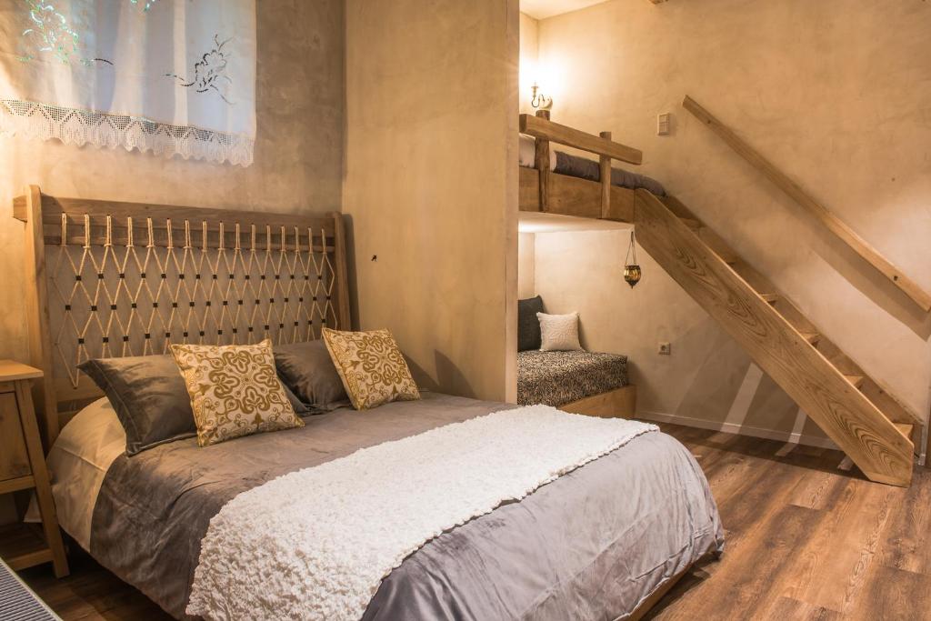 a bedroom with a bed and a staircase at «Σκλάβας Χνάρι» Παραδοσιακός Ξενώνας in Magoúliana