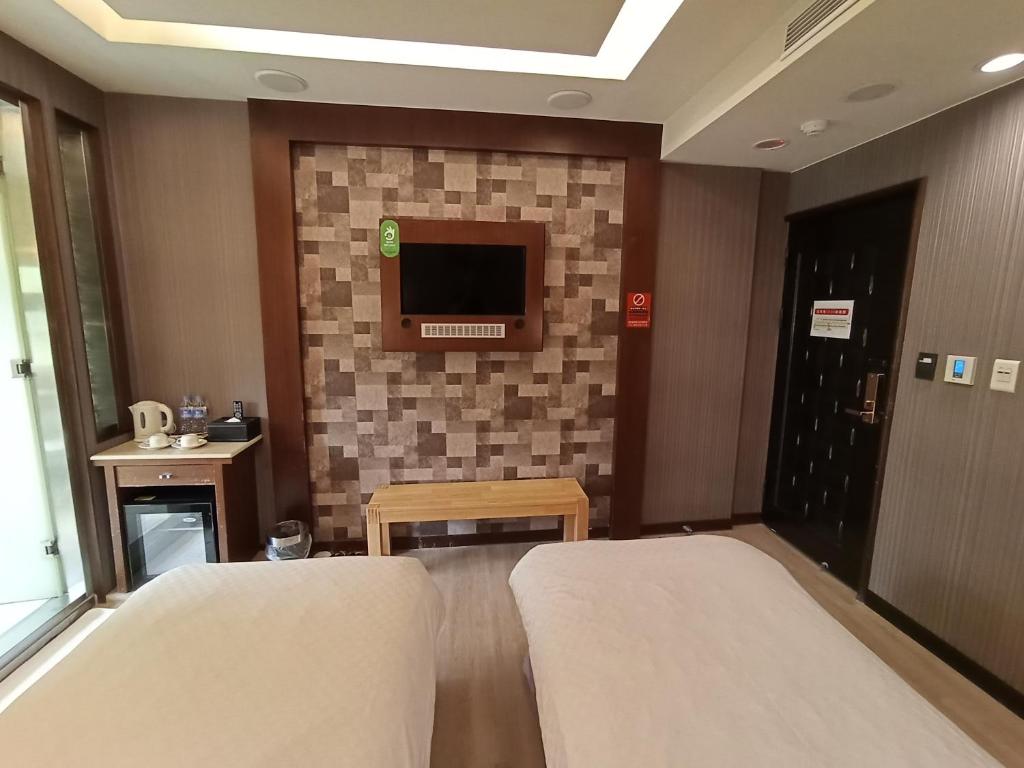 a hotel room with two beds and a tv at Jin Yong Quan Spa Hotspring Resort in Wanli District