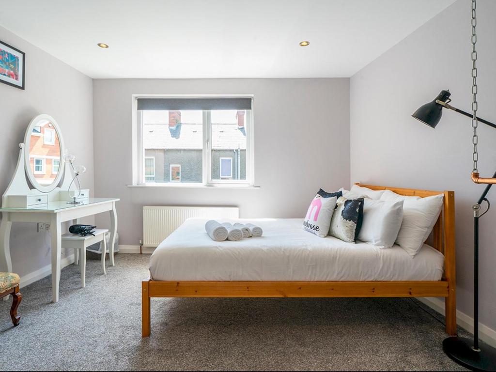 a bedroom with a bed with pillows and a window at Pass the Keys Luxury 2Bed 2Bath Townhouse - Perfect for Winter Stay in Belfast