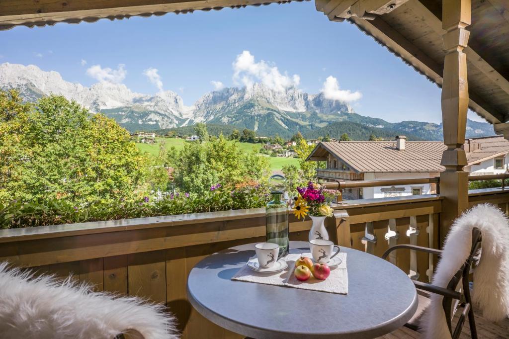 a table on a balcony with a view of mountains at Appartements Schedererhaus in Going