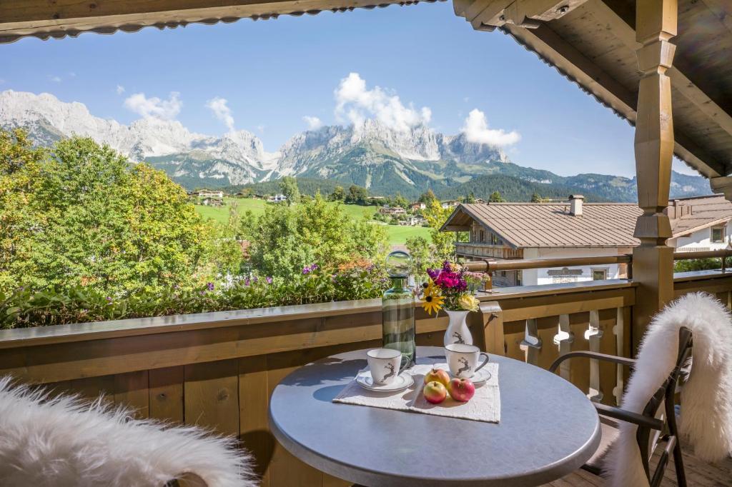 a table on a balcony with a view of mountains at Appartements Schedererhaus in Going am Wilden Kaiser