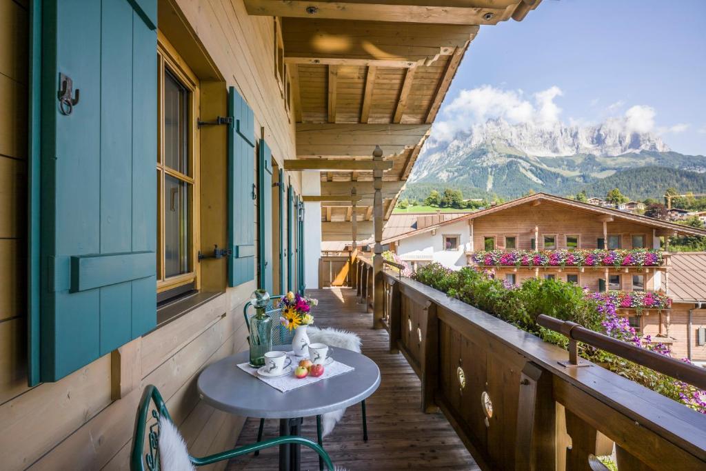 a table on a balcony with a view of a mountain at Appartements Schedererhaus in Going