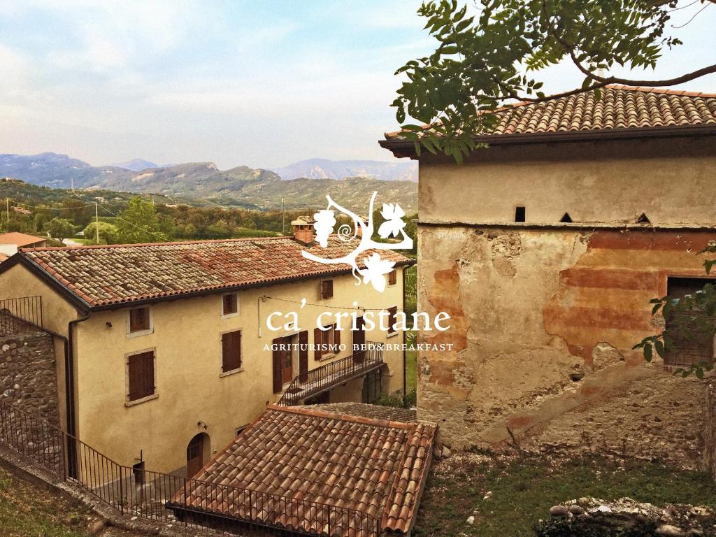 an external view of an old house with mountains in the background at Agriturismo Ca' Cristane in Rivoli Veronese