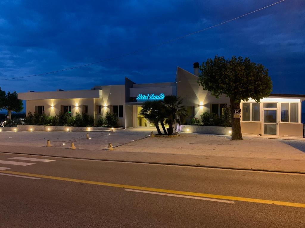 un bâtiment situé sur le côté d'une rue la nuit dans l'établissement Hotel Corallo, à Numana