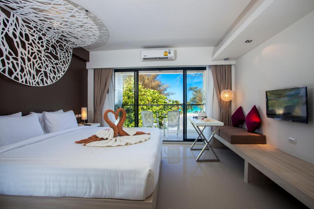 a bedroom with a bed with a heart decoration on it at Coral Inn in Karon Beach