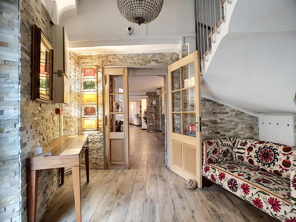 a living room with a couch and a table at Hôtel le Chardon Bleu in Sainte-Maxime