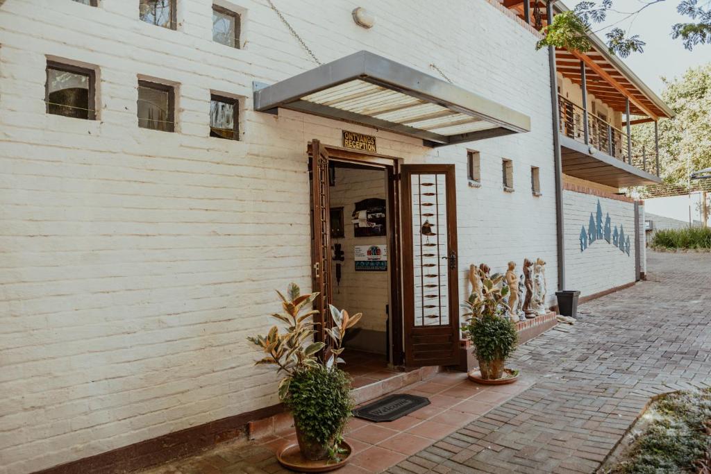 a door to a building with potted plants in front of it at Ons Dorpshuis Guesthouse in Rustenburg