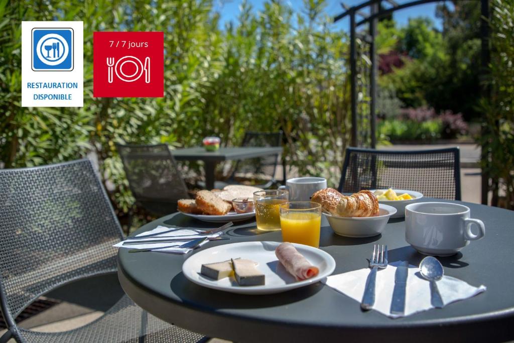 una mesa negra con desayuno en ibis budget Brignoles Provence, en Brignoles