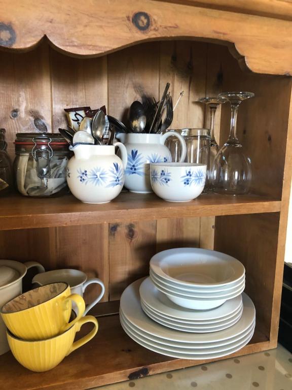 a shelf with plates and cups and other dishes at The Stoep in Paignton