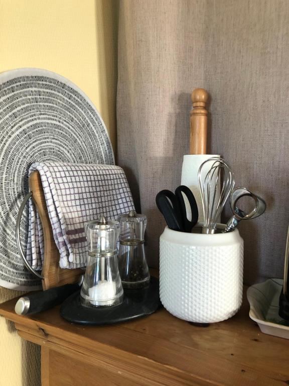 a counter with a container of utensils on it at The Stoep in Paignton