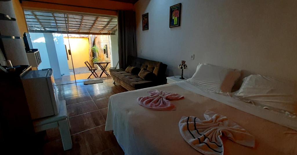 a bedroom with a bed and a living room at Villa ALMM in Lençóis