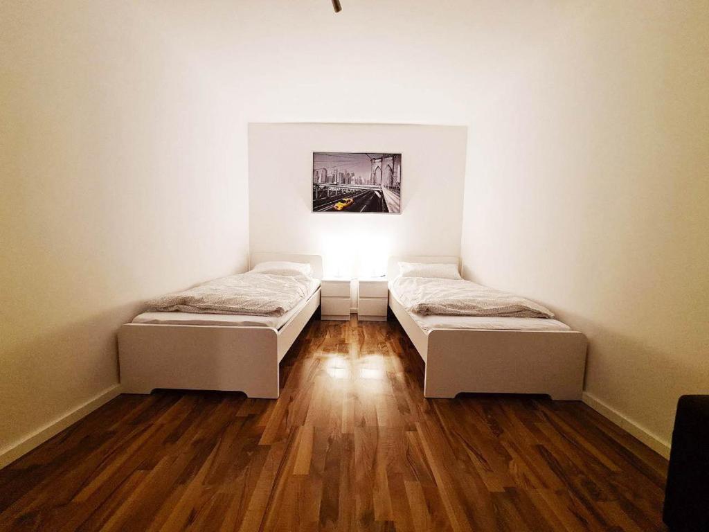 2 camas en una habitación con suelo de madera en Moderne 3 Zimmer Ferienwohnung, en Celle