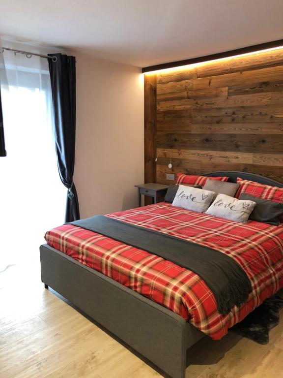 a bedroom with a bed with a wooden headboard at Maison Altea in Courmayeur