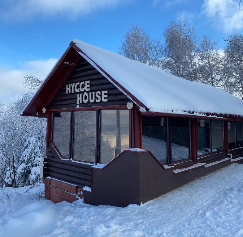 ein Haus im Schnee mit einem Schild drauf in der Unterkunft Hygge House in Vyshka