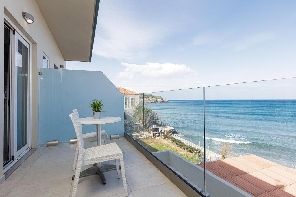 balcone con tavolo e vista sull'oceano di Seaside Palette Suites a Rethymno