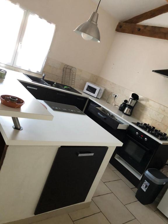 een keuken met een wit aanrecht en een fornuis bij le verso in Narbonne