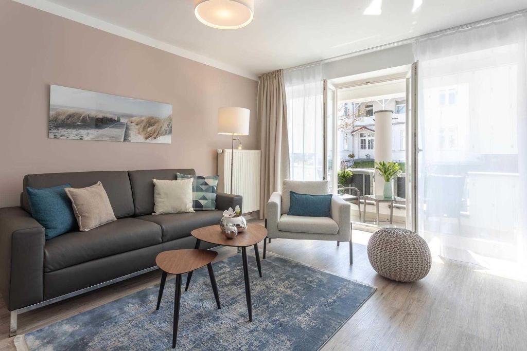 uma sala de estar com um sofá e uma mesa em Villa Strandidyll FeWo pier25 N 1 em Binz