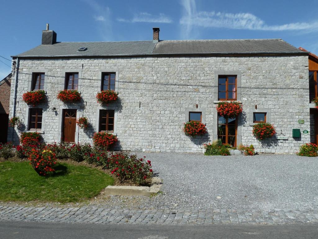 a white brick house with flowers in front of it at Le Clos Marie in Ciney