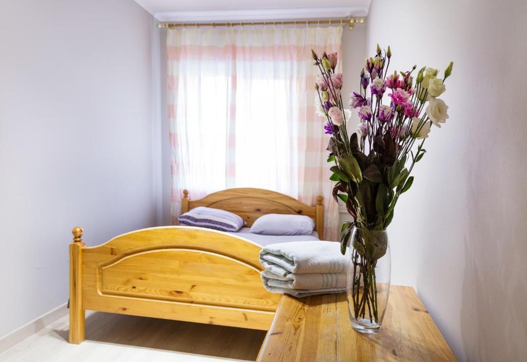 een slaapkamer met een bed met een vaas met bloemen op een tafel bij Квартира на Печерске in Kiev