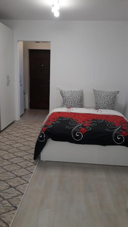 1 dormitorio con 1 cama con manta roja y negra en Irvin Apartament en Iaşi