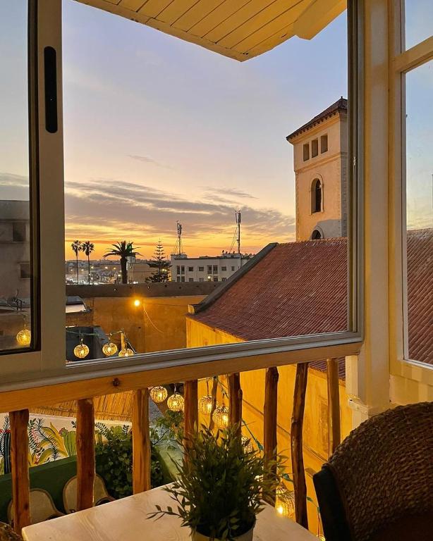 a balcony with a view of a city from a window at Art house in El Jadida