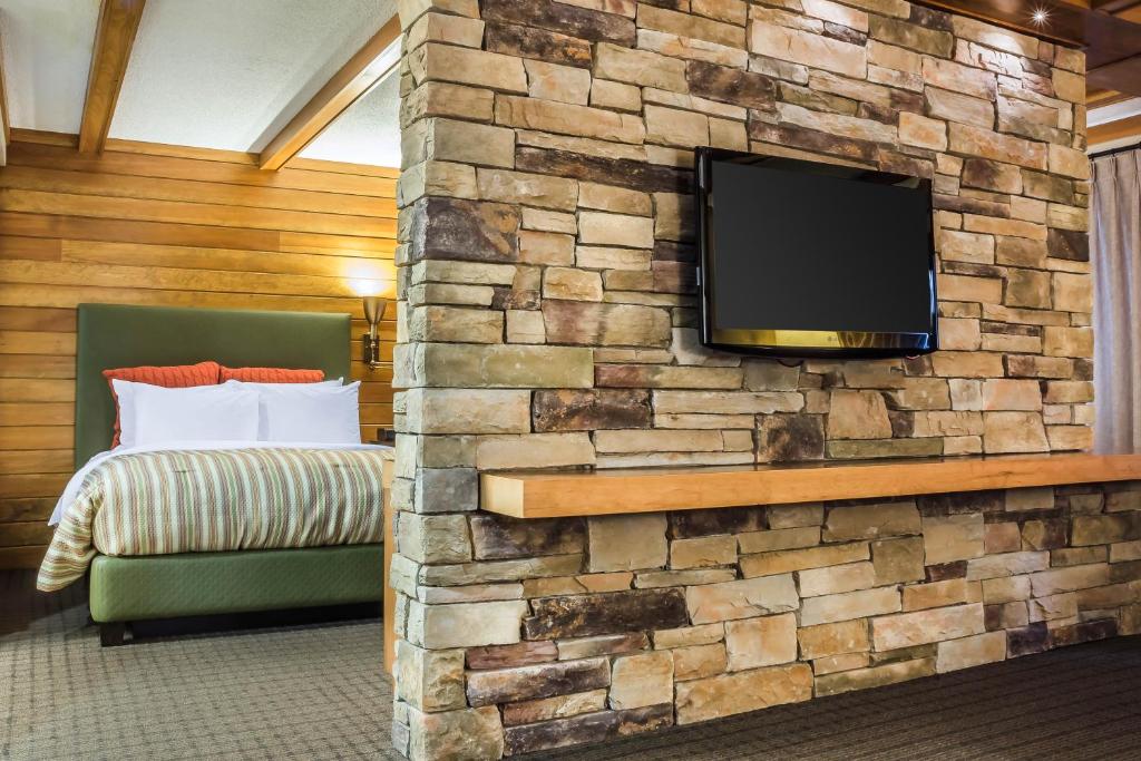 a bedroom with a stone wall with a flat screen tv at Comfort Inn The Pointe in Niagara Falls