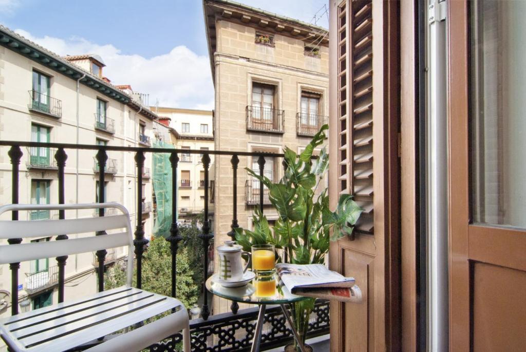 Un balcón con una mesa y una taza de café. en MIT House Plaza Mayor III en Madrid, en Madrid