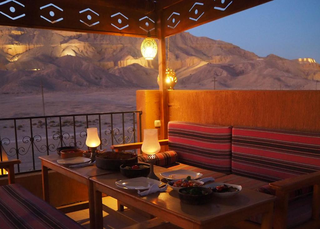 a restaurant with a table and chairs with a view of the desert at Malkata House in Luxor