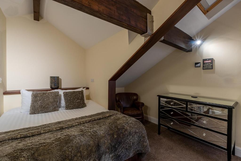 ボウネス・オン・ウィンダミアにあるLakes Hotel & Spaの屋根裏のベッドルーム(ベッド1台、椅子付)
