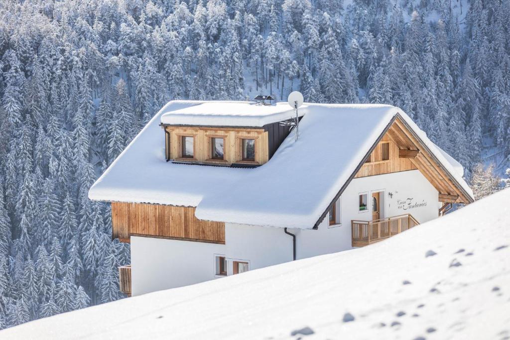 une maison sur un toit recouvert de neige dans l'établissement Ciasa Funtanies Sas dla Crusc, à San Martino in Badia