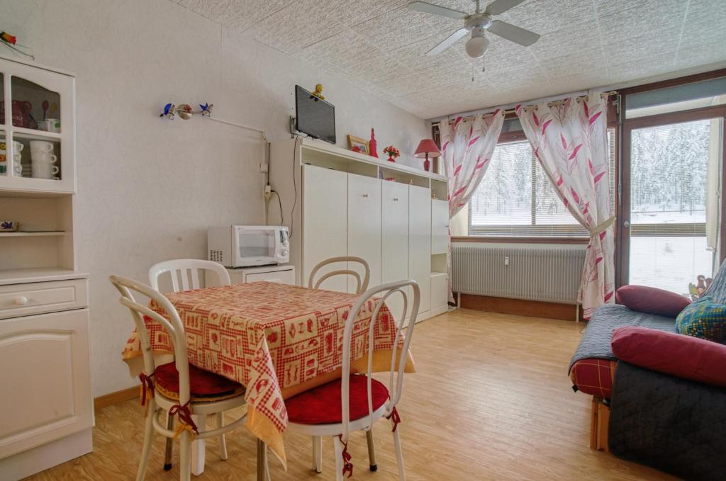 cocina y comedor con mesa y sillas en Les Cimes de Belle Hutte, en La Bresse