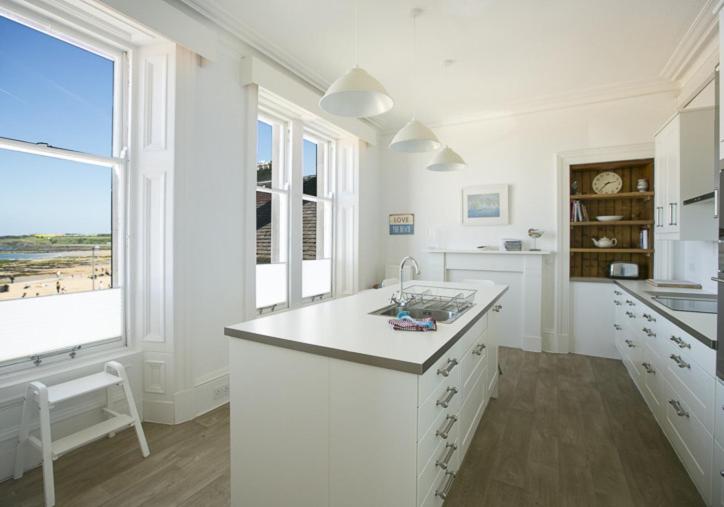 a white kitchen with a view of the beach at Linda Vista in North Berwick