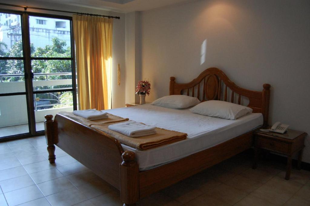 a bedroom with a bed and a large window at Veerachai Court in Chiang Mai