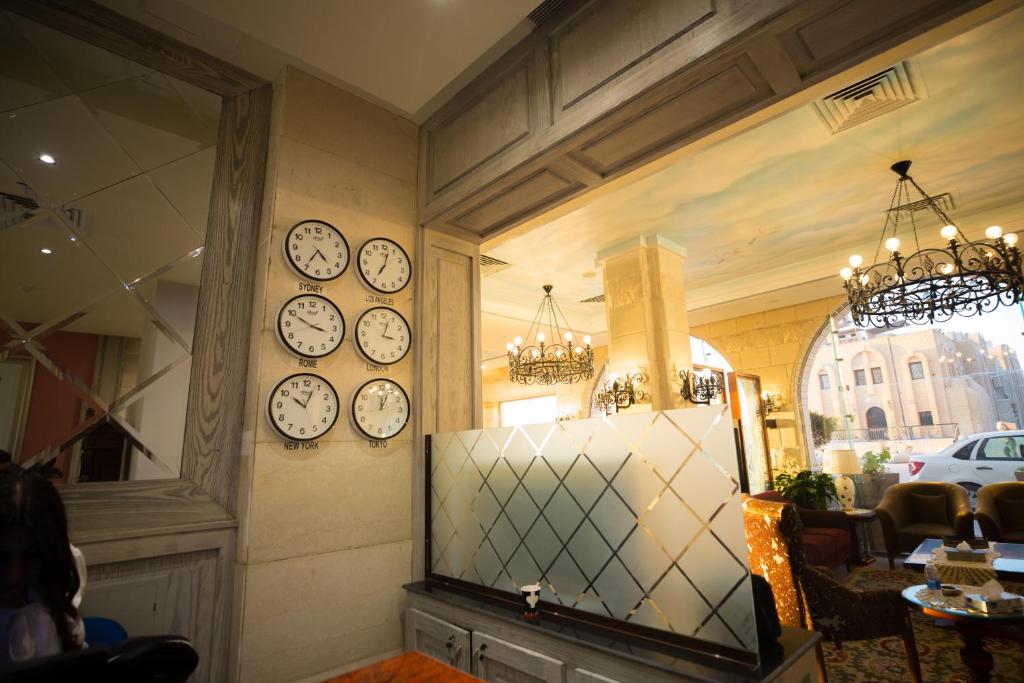 a room with clocks on the walls of a restaurant at Holy Family Hotel in Jabal aţ Ţayr