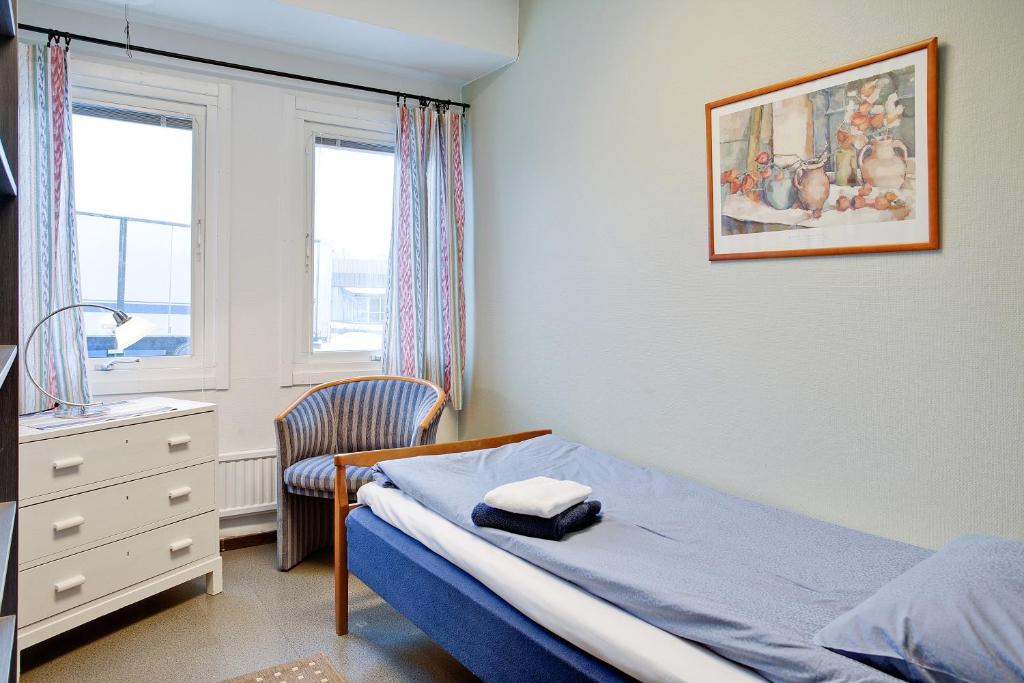 a bedroom with a bed and a dresser and window at Bed's Motell & Rumsuthyrning in Norrköping