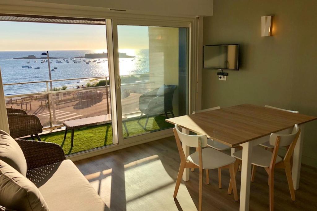 - un salon avec une table et une vue sur l'océan dans l'établissement Magnifique duplex super cosy Vue mer 180, à Ploemeur