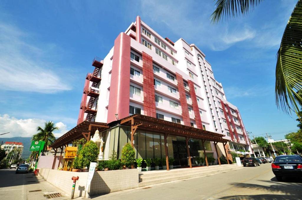 a large pink building on a city street at Mayflower Grande Hotel Chiang Mai in Chiang Mai